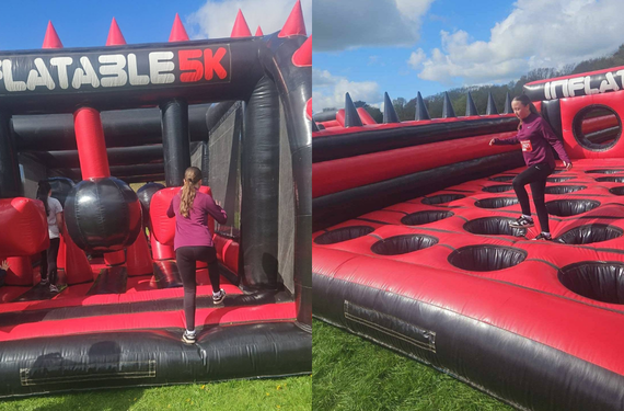 A young girl running through inflatable obstacles